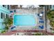 Aerial view of a community pool surrounded by chairs and greenery with nearby condominiums at 3002 W Cleveland St # D4, Tampa, FL 33609