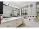 This bathroom features a double vanity with marble counters, a large mirror with sconces, and natural light at 3018 Pemberton Trace Ct, Plant City, FL 33565