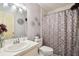 Cozy bathroom with patterned shower curtain, white vanity, and decorative wall accents at 3018 Pemberton Trace Ct, Plant City, FL 33565