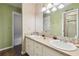 Well-lit bathroom with double sinks, decorative wallpaper, and ample countertop space, perfect for morning routines at 3018 Pemberton Trace Ct, Plant City, FL 33565