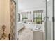 Bright bathroom featuring a soaking tub, glass shower, and vanity with storage, illuminated by natural light from two windows at 3018 Pemberton Trace Ct, Plant City, FL 33565