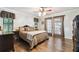 Well-lit bedroom featuring hardwood floors, large bed, and plenty of natural light at 3018 Pemberton Trace Ct, Plant City, FL 33565