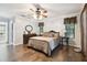 Cozy bedroom featuring hardwood floors, natural light, and a dresser with a mirror at 3018 Pemberton Trace Ct, Plant City, FL 33565