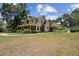 Spacious property showcasing a charming two-story home with a long driveway and lush landscaping, offering serene privacy at 3018 Pemberton Trace Ct, Plant City, FL 33565