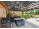 Inviting covered gazebo with wicker sofa, table, ceiling fan and outdoor rug at 3018 Pemberton Trace Ct, Plant City, FL 33565