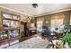 Cozy living room featuring a piano, bar area, hardwood floors, and natural light from the surrounding windows at 3018 Pemberton Trace Ct, Plant City, FL 33565