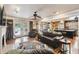 Spacious living room with hardwood floors, a fireplace, and views of the kitchen and backyard pool through French doors at 3018 Pemberton Trace Ct, Plant City, FL 33565
