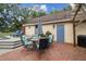 Outdoor patio featuring a table with chairs, umbrella, and steps to a deck at 3018 Pemberton Trace Ct, Plant City, FL 33565