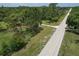 Scenic aerial view of a property surrounded by lush greenery, showcasing a long driveway and natural landscape at 3203 21St Se Ave, Ruskin, FL 33570