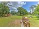 Extensive backyard featuring mature trees, outbuildings, wood pile, and privacy fence at 3203 21St Se Ave, Ruskin, FL 33570