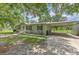 Well-maintained home with a covered parking area, gravel driveway and manicured landscaping at 3203 21St Se Ave, Ruskin, FL 33570