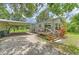 View of the home's exterior, with carport and a wooden deck with stairs at 3203 21St Se Ave, Ruskin, FL 33570