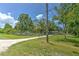 Fenced front yard features a well-manicured lawn and shaded areas provided by trees at 3203 21St Se Ave, Ruskin, FL 33570