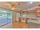 Functional kitchen with white appliances, wood cabinets, and a sliding glass door to the lanai at 3203 21St Se Ave, Ruskin, FL 33570