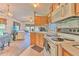 View of the kitchen with white appliances and wooden cabinetry, flowing into living space at 3203 21St Se Ave, Ruskin, FL 33570