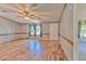 Spacious living room featuring wood-look laminate floors, natural light, and a ceiling fan at 3203 21St Se Ave, Ruskin, FL 33570