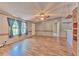 Spacious living room featuring wood-look laminate floors, natural light, and a ceiling fan at 3203 21St Se Ave, Ruskin, FL 33570