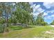 Fenced front yard showing large green space and home in the background at 3203 21St Se Ave, Ruskin, FL 33570