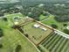 Picturesque property featuring a lovely home, pool, storage building, all enveloped by lush fields and established trees at 3212 E Merrin Rd, Plant City, FL 33567