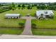 Aerial view of a serene property featuring a home, detached garage, and expansive green acreage at 3212 E Merrin Rd, Plant City, FL 33567