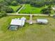 Aerial view of home with large lawn, long driveway, nearby road and pool in back at 3212 E Merrin Rd, Plant City, FL 33567