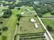 Sprawling acreage featuring a beautiful home with a pool, plus storage building, surrounded by vast landscapes and mature trees at 3212 E Merrin Rd, Plant City, FL 33567