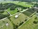 Lush acreage featuring a beautiful home with a pool, bordered by mature trees and manicured fields at 3212 E Merrin Rd, Plant City, FL 33567