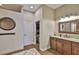 Well-lit bathroom featuring a wood vanity, granite countertop, decorative mirror, and a view into the shower at 3212 E Merrin Rd, Plant City, FL 33567