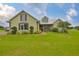Inviting exterior of home featuring a lush lawn, mature landscaping, and charming architectural details at 3212 E Merrin Rd, Plant City, FL 33567