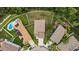 An aerial view of homes with fenced yards, some featuring pools and solar panels, set in a lush neighborhood at 3305 Hoylake Ct, Land O Lakes, FL 34638