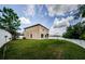 Backyard view of the home featuring a white fence, and well-manicured green lawn at 3305 Hoylake Ct, Land O Lakes, FL 34638