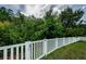 Fenced backyard with green grass and lush trees enhances the home's serene setting at 3305 Hoylake Ct, Land O Lakes, FL 34638