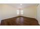 Sunny bedroom featuring wood-look flooring, two windows, and neutral walls for relaxation at 3305 Hoylake Ct, Land O Lakes, FL 34638