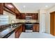A kitchen features stainless steel appliances, including a microwave and oven, with dark wood cabinets and granite countertops at 3305 Hoylake Ct, Land O Lakes, FL 34638