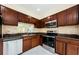 A kitchen features stainless steel appliances, including a microwave and oven, with dark wood cabinets and granite countertops at 3305 Hoylake Ct, Land O Lakes, FL 34638