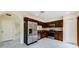 Modern kitchen with stainless steel appliances, dark wood cabinets, and marble-style flooring at 3305 Hoylake Ct, Land O Lakes, FL 34638