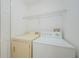 A laundry room with a standard size washer and dryer has an overhead wire rack for additional storage at 3305 Hoylake Ct, Land O Lakes, FL 34638