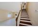 A staircase with wooden steps and white risers leads up from the living area at 3305 Hoylake Ct, Land O Lakes, FL 34638