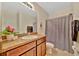 Bathroom features a single sink vanity, vanity mirror, and shower with patterned curtain at 3320 Pleasant Willow Ct, Brandon, FL 33511