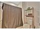 Cozy bathroom with a toilet, shelving unit, and a shower with patterned curtain at 3320 Pleasant Willow Ct, Brandon, FL 33511