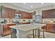 Bright kitchen features a large island with a sink, stainless steel appliances, and rich wood cabinets at 3320 Pleasant Willow Ct, Brandon, FL 33511