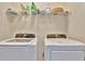 Convenient laundry area equipped with a modern washer and dryer beneath a storage shelf at 3320 Pleasant Willow Ct, Brandon, FL 33511