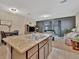 Open-concept living space includes a kitchen island and seating area with a TV and entertainment center at 3320 Pleasant Willow Ct, Brandon, FL 33511