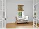 Bright bedroom with wood floors, a crib, and natural light through a window at 334 11Th Ne Ave, St Petersburg, FL 33701