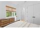 Bright bedroom with woven blinds, a wooden dresser, and double doors at 334 11Th Ne Ave, St Petersburg, FL 33701