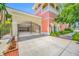 Exterior view of a gated entrance leading to the garage, with tropical landscaping and a peach and yellow color scheme at 340 1St N St # I, St Petersburg, FL 33701