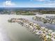 Expansive aerial view of waterfront homes, docks, and boats under a bright, partly cloudy sky at 352 La Hacienda Dr, Indian Rocks Beach, FL 33785