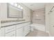 Bright bathroom featuring a granite countertop vanity and shower-tub combo with built in shelves at 352 La Hacienda Dr, Indian Rocks Beach, FL 33785