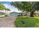 Charming home with a brick driveway, beautiful landscaping and a spacious two-car garage at 352 La Hacienda Dr, Indian Rocks Beach, FL 33785