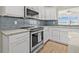 Modern kitchen featuring stainless steel appliances and stylish backsplash at 352 La Hacienda Dr, Indian Rocks Beach, FL 33785